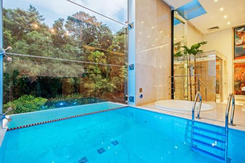 a swimming pool in a house with a tub and a window at Motel Acqua (Adult Only) in Curitiba