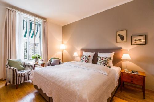 ein Schlafzimmer mit einem Bett, einem Stuhl und einem Fenster in der Unterkunft Boutique Hotel Seegarten in Zürich