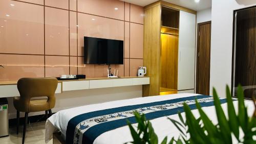 a hotel room with a bed and a television at Hestia Hotel in Móng Cái