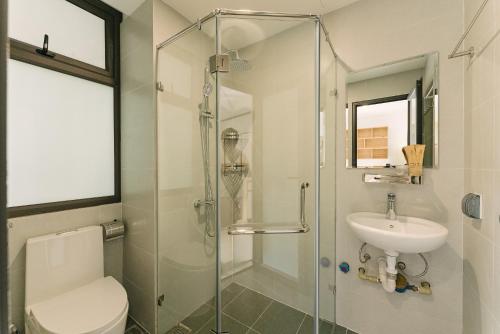 a bathroom with a shower and a toilet and a sink at Boho Apartment 81 - Ton That Thiep in Hanoi