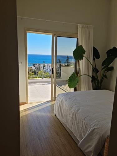 a bedroom with a bed and a view of the ocean at Luxury Seaview Limassol Villa Pool Jacuzzi Sauna in Limassol