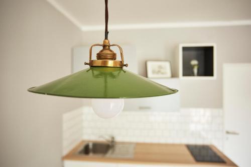 a green light hanging over a kitchen sink at Vlnka Apartments in Piešťany