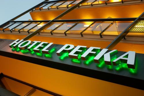 a sign for a hotel facility on the side of a building at Pefka Hotel in Thessaloniki