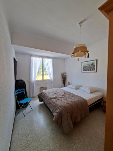 une chambre avec un grand lit et une chaise bleue dans l'établissement Domaine Des Mimosas, à Argelès-sur-Mer