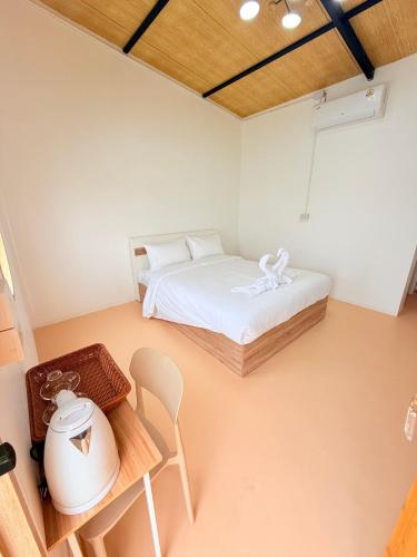 a bedroom with a bed and a table and chair at ชุ่มฉ่ำ พูลวิลล่า พิจิตร in Ban Tha Krathu (1)