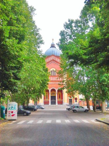 a large orange building with a dome on a street at Luna del Belvedere in Asti