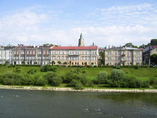 un gran edificio en una colina junto a un río en Pokoje Gościnne, en Przemyśl