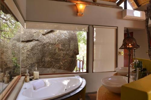 La salle de bains est pourvue de 2 lavabos et d'une grande fenêtre. dans l'établissement Wild & Free Private Game Lodge, à Mabula