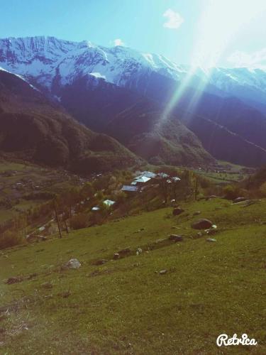 a view of a mountain with the sun shining on it at Guesthouse in Lankhvri in Mestia