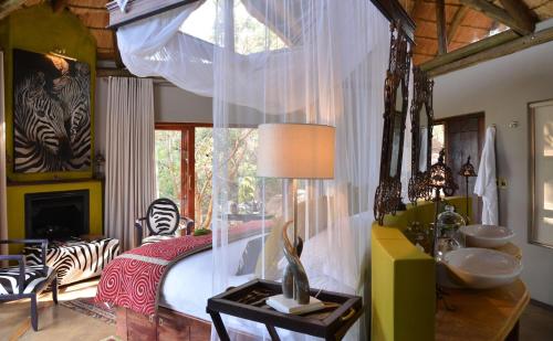 a bedroom with a canopy bed with a zebra at Thakadu Bush Lodge Naka Sanga in Mabula