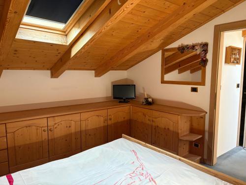 a bedroom with wooden cabinets and a tv on a roof at Casa Defrancesco in Cavalese