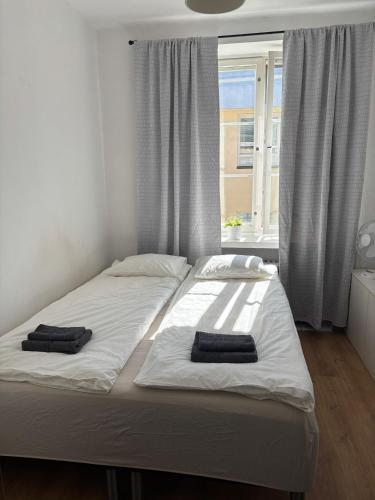 a bed with two towels on it in a room with a window at Foliate Living Silmu in Helsinki