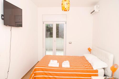 フィウミチーノにあるSun Garden l.t.のベッドルーム1室(オレンジと白のストライプの毛布付きのベッド1台付)