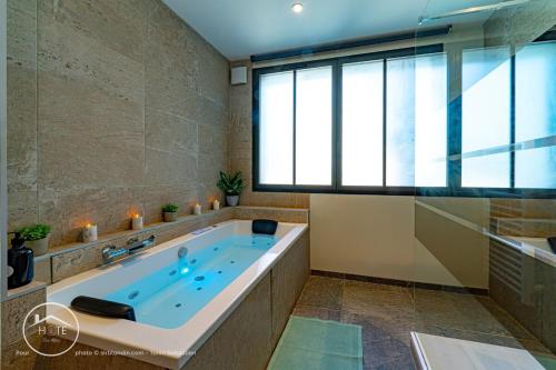 a bathroom with a large tub with a window at Chic & Spa l Ascenseur l Terrasse centre ville in Chambéry