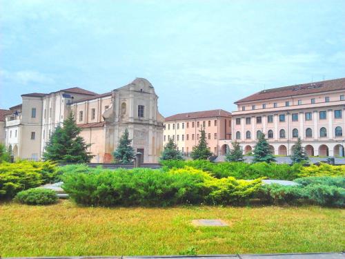 a group of buildings with a field of grass in front at Luna del Belvedere in Asti
