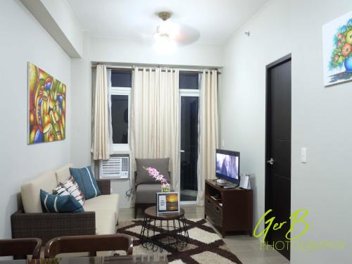 a living room with a couch and a tv at Gerbi's Condoplace at Oceanway Residences in Sampong
