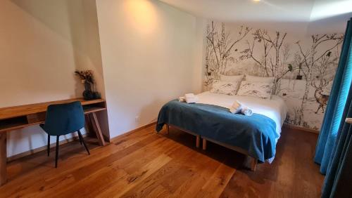 a small bedroom with a bed and a desk at Domaine de Rozan - Col de Porte, Chartreuse - Grenoble in Sarcenas