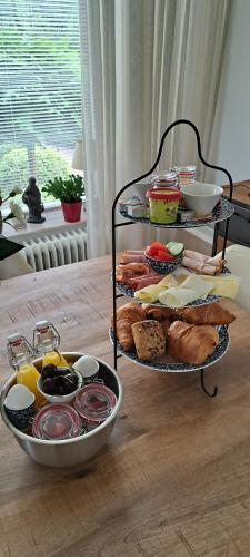 a tray of food on a table with bread and pastries at De beukenboom Bed and Breakfast in Geleen