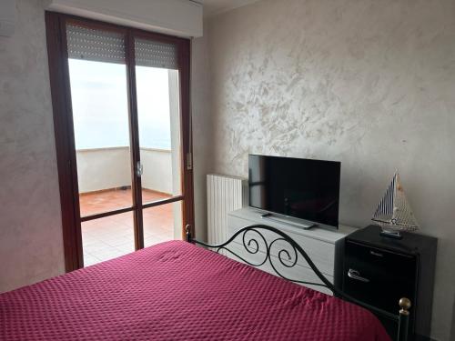 una camera da letto con un letto e una TV a schermo piatto di Vista D' Amare a Porto Potenza Picena