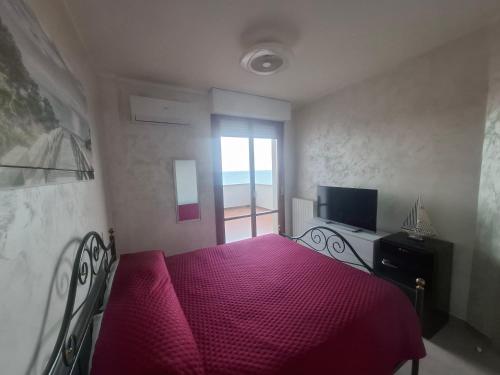 una camera da letto con un letto con lenzuola rosse e una finestra di Vista D' Amare a Porto Potenza Picena