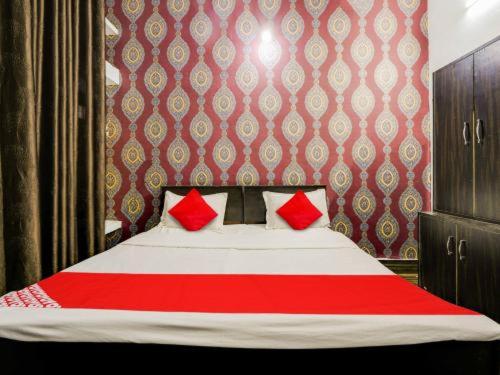 a red and white bed with red pillows in a bedroom at Shiva Palace in Gwalior