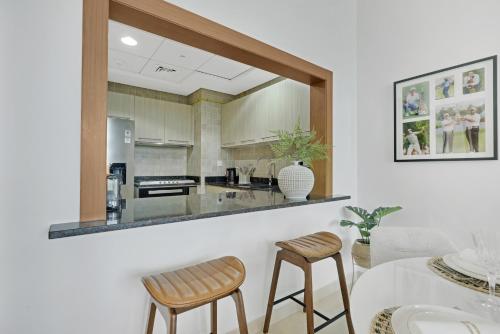 a kitchen with a counter with two chairs and a table at The Green Keepers Look-out in Abu Dhabi