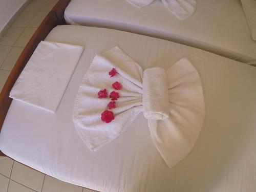 a white towel with red berries on a table at Villa Ariadni in Skiathos
