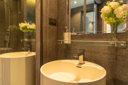 a bathroom with two sinks and a vase of flowers at C118 Rooftop Pool Condo Walk to Beach, Gym, Wi-Fi in Kamala Beach