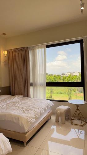 a bedroom with a bed and a large window at 鹿港 尋鹿好旅 民宿 in Lugang