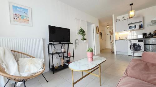 un salon avec un canapé et une table dans l'établissement l'Ecrin de Malo - Vue Mer, à Dunkerque