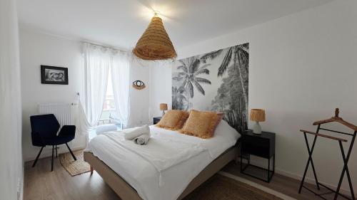 - une chambre avec un lit et une fresque murale de palmiers dans l'établissement l'Ecrin de Malo - Vue Mer, à Dunkerque