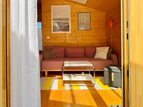 un salon avec un canapé et une table basse dans l'établissement Hochwertiges Tiny House 'Elbhütte' mit Wiesenblick 101, à Bleckede