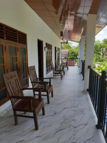 a row of chairs sitting on a porch at Wilpattu Lakwin Guest in Pahala Maragahawewa