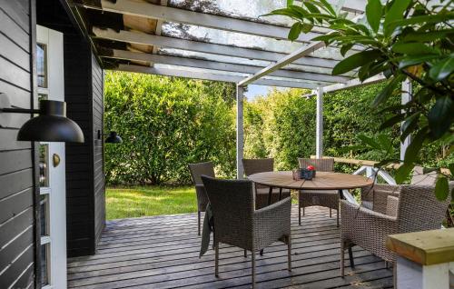 Un patio con una mesa y sillas en una terraza. en 3 Bedroom Amazing Home In Hornbæk, en Hornbæk
