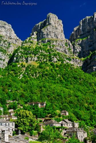 a mountain with houses and buildings on it at Papaevangelou Hotel in Papigko