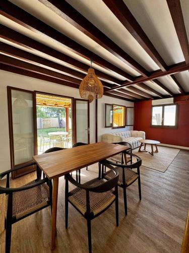 a dining room with a wooden table and chairs at Maison au charme créole - Accès privé à la plage in Étang-Salé les Bains