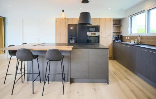 une cuisine avec un grand îlot et des tabourets de bar dans l'établissement Nice Home In Saint-Pabu, à Saint-Pabu