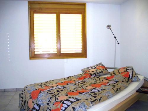 a bed in a bedroom with a window at Casa Luna by HolAp SA in Cugnasco