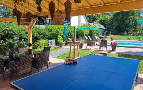 a blue table under a pavilion with a pool at Beautiful Home In Thierville With Wifi in Thierville