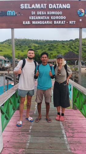 a group of three people standing on a wooden bridge at Komodo Village Tour & Homestay in Komodo