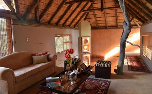 a living room with a couch and a table at Thakadu Bush Lodge Naka Sanga in Mabula