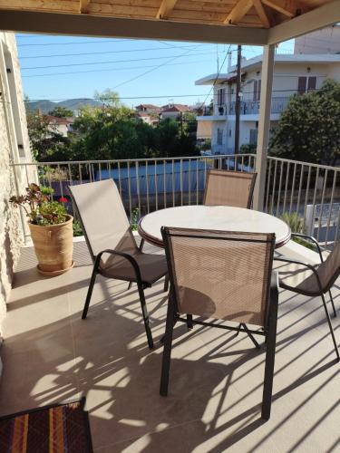 a patio with a table and chairs on a balcony at Fotini's House in Ligourio