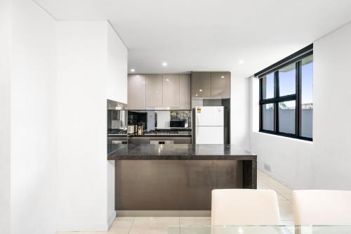 a kitchen with a black counter and white appliances at 3Bds& FishM &Citylife Super Cozy in Sydney