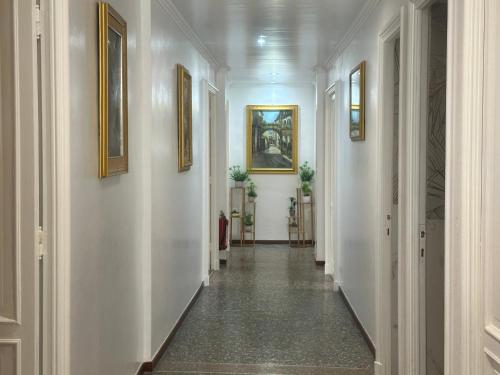 a hallway with white walls and paintings on the walls at Genova Antica in Genova