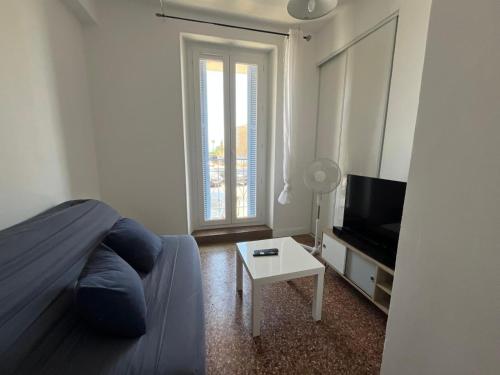 - un salon avec un lit, une télévision et une table dans l'établissement Casamea- Famille, Plage 2 min, à Ajaccio