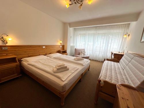 a bedroom with two beds and a window at Hotel Arnika Wellness in Passo San Pellegrino