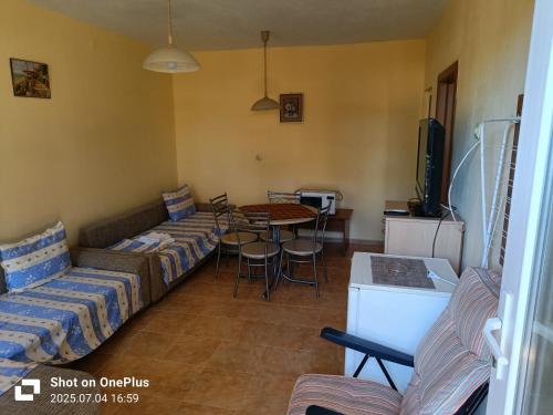ein Wohnzimmer mit Sofas, Tisch und Fernseher in der Unterkunft Вила Фернандес in Tschernomorez