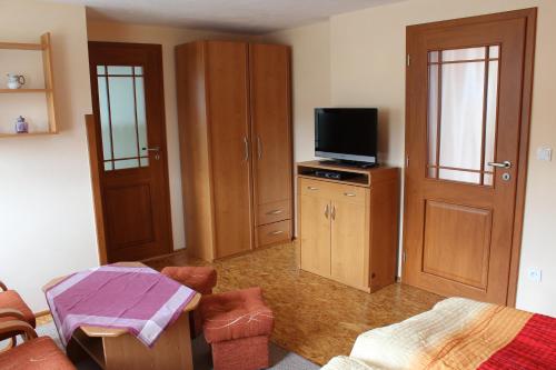 ホイソヴァ・ストラージュにあるŠumavská chalupaのリビングルーム(テレビ、家具付)が備わる客室です。
