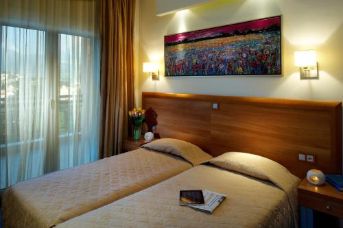 a bedroom with two beds and a large window at Pefka Hotel in Thessaloniki