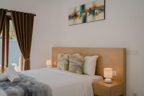 Ένα ή περισσότερα κρεβάτια σε δωμάτιο στο Radika Guest House Jimbaran